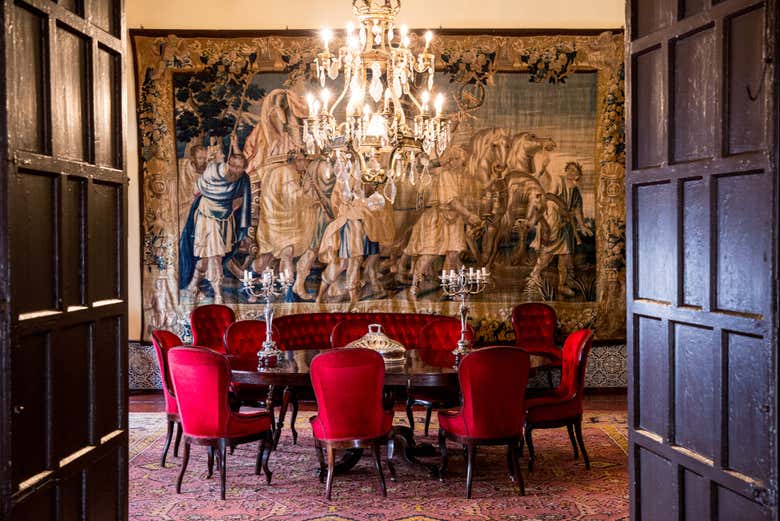 Un tavolo con un arazzo sullo sfondo