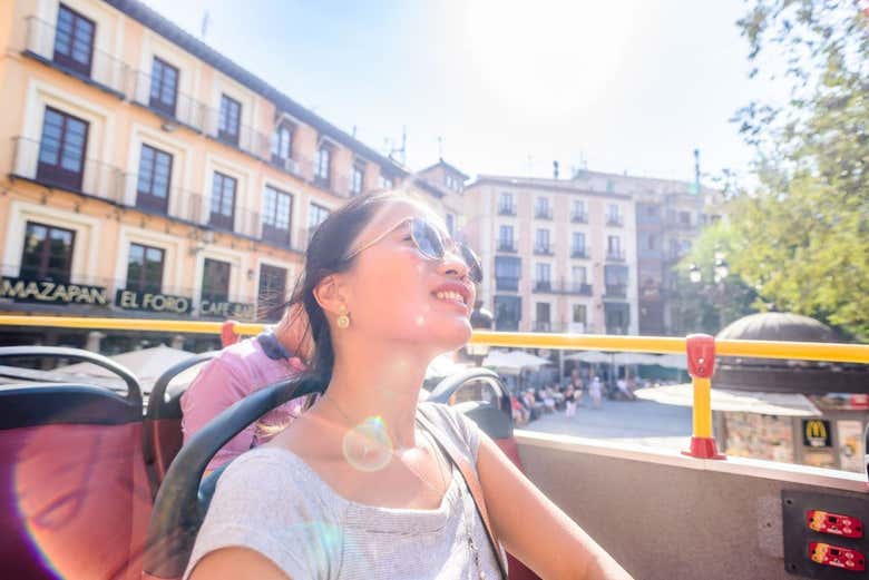 Turista a bordo del autobús descapotable