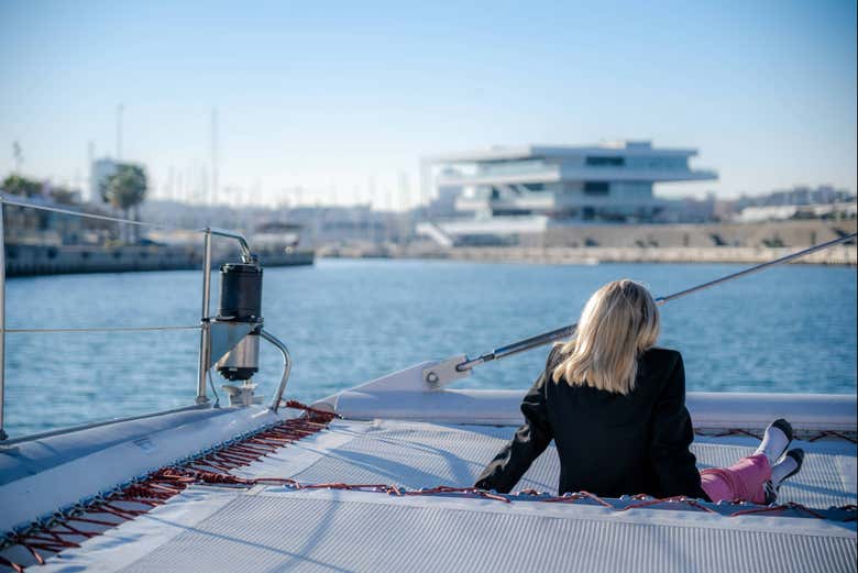Femme à bord du catamaran contemplant le port de Valence