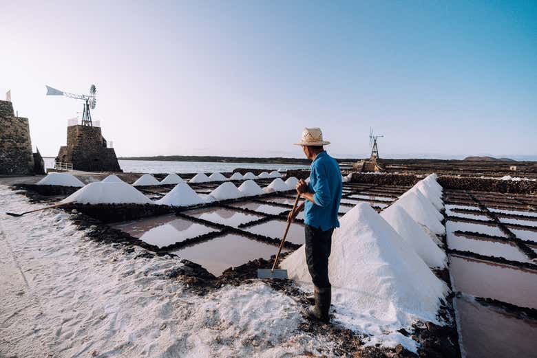 Salinero trabajando y haciendo montañas de sal