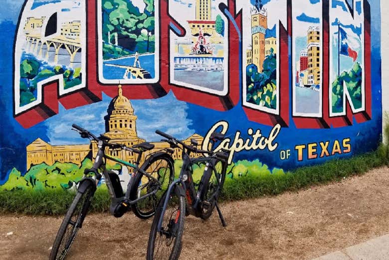 Duas bicicletas junto a um mural de arte urbana de Austin