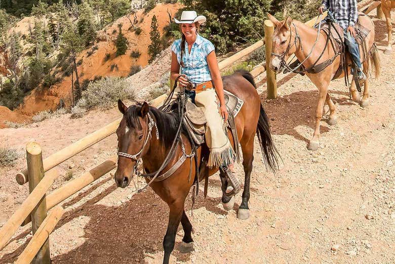 Ride horses through  Bryce Canyon's reddish landscape
