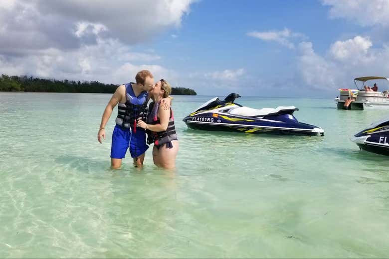 Beso de amor en una zona paradisiaca bajados de la moto de agua