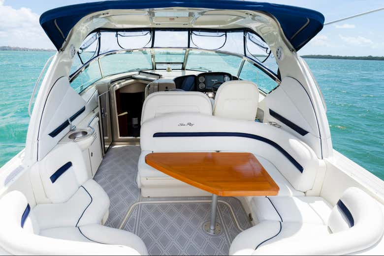 Cubierta con asientos blancos y una mesa de madera