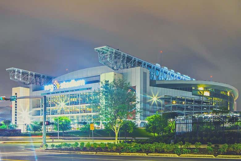 Fachada iluminada del NRG Stadium al anochecer