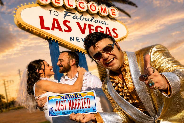 Gold Elvis holding "Just Married" sign in front of couple at the
