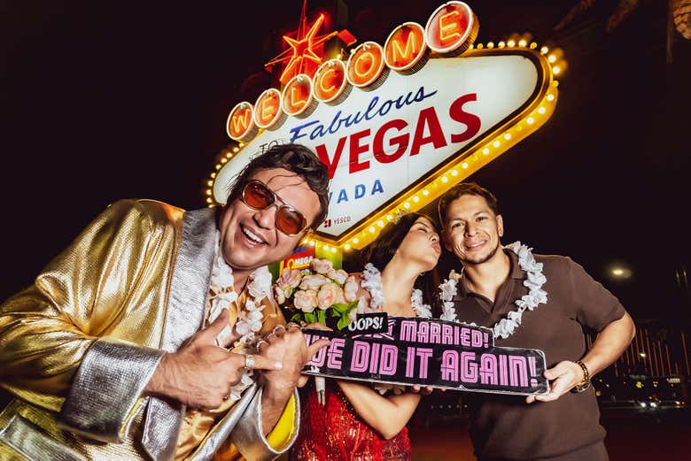 Gold Elvis at the Las Vegas sign with a vow renewal couple holdi