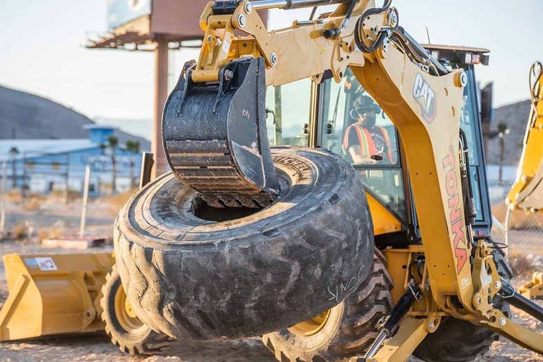 Raccogliendo uno pneumatico con l'escavatore