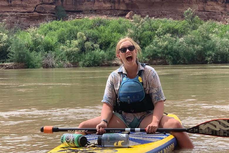 Une fille assise sur une planche de paddle
