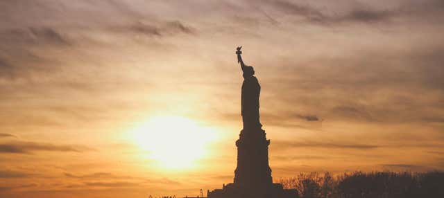 Cruzeiro noturno por Manhattan e pela Estátua da Liberdade