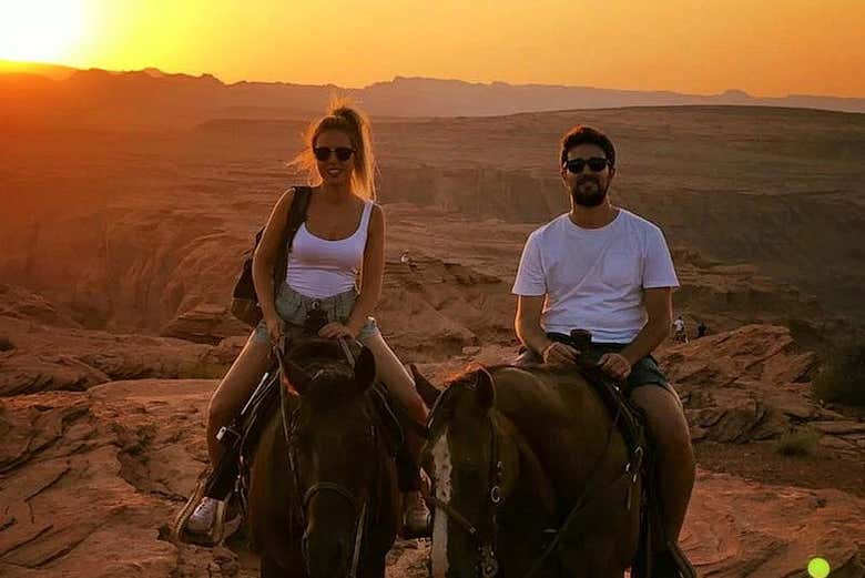 Um casal a cavalo ao pôr do sol