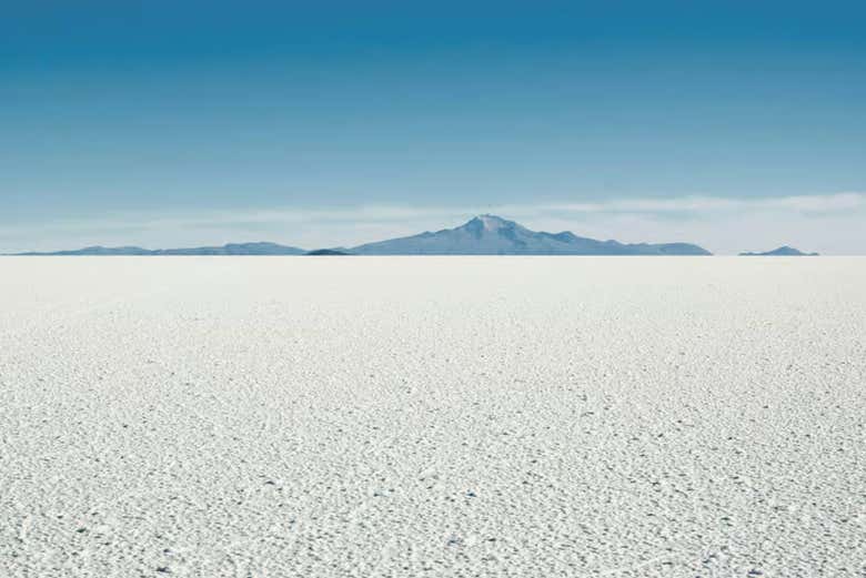 Il contrasto tra le saline e le montagne in lontananza