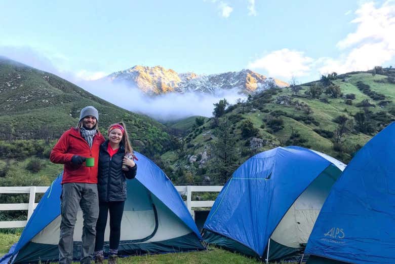 Una pareja junto a las tiendas de campaña