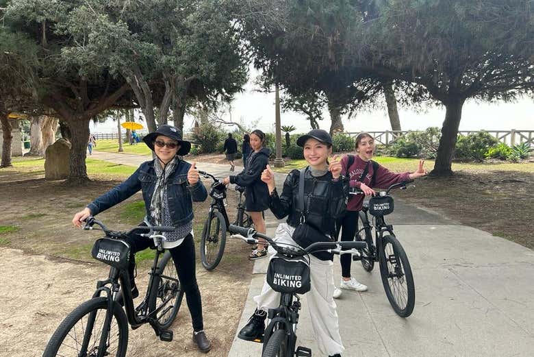 Cuatro chicas con las bicicletas por Santa Mónica