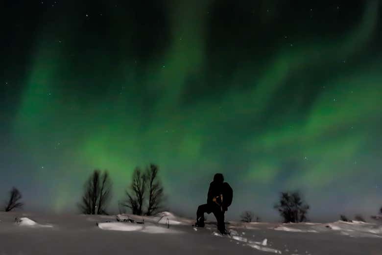 Un turista contempla una magnifica aurora boreale
