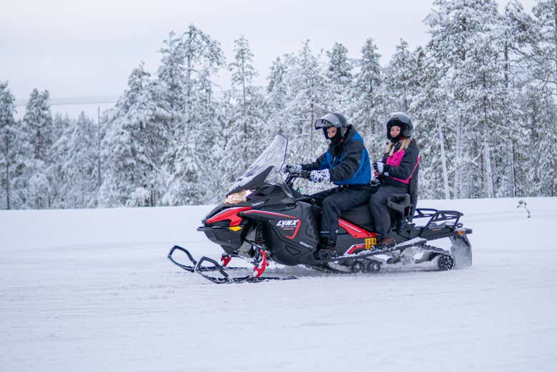 Conduciendo la moto de nieve en la aldea de Papá Noel