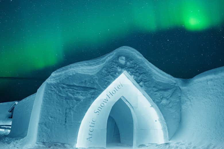 Cruzad la entrada de nieve bajo la aurora boreal