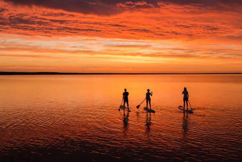 Practicando Stand Up Paddle bajo el sol de medianoche