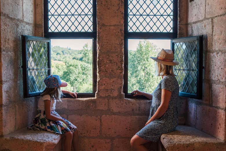 Observando los paisajes desde una ventana del castillo