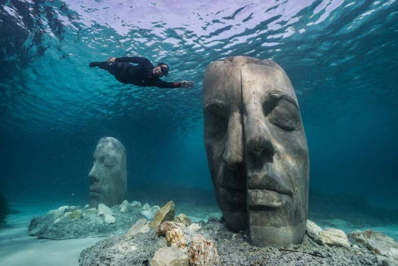 Statues de visages sous l'eau
