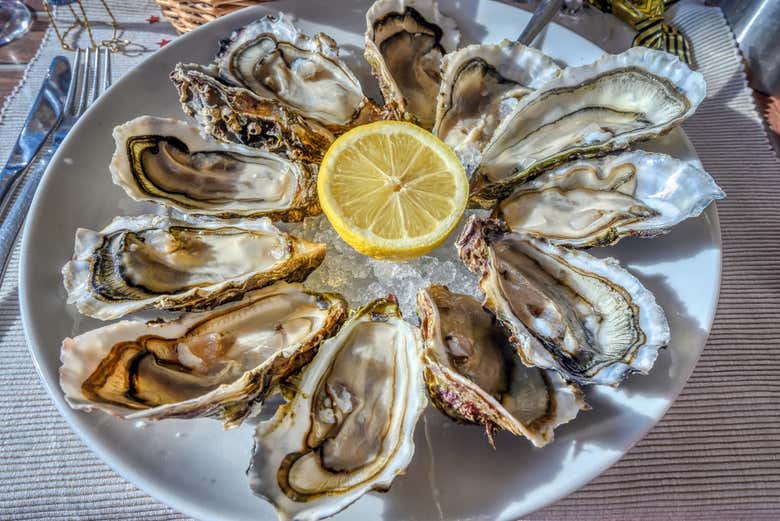 Una docena de deliciosas ostras con concha y medio limón