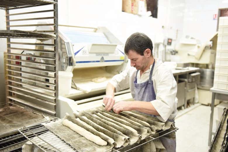 Panadero profesional preparando baguettes 
