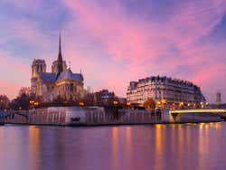 A purple and pink sky over the River Seine and Notre Dame