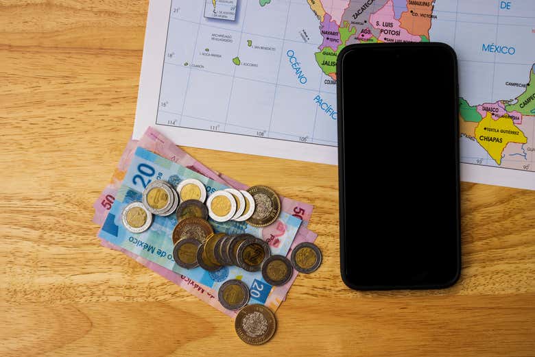 Celular, dinheiro e mapa do México preparados para a viagem