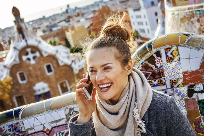 Hablando por un teléfono móvil en el Parque Güell de Barcelona