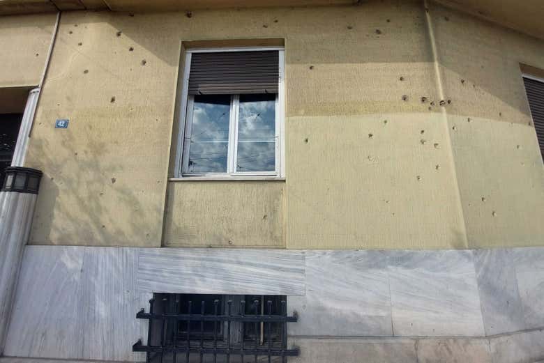 Fachada de una casa con marcas de proyectiles