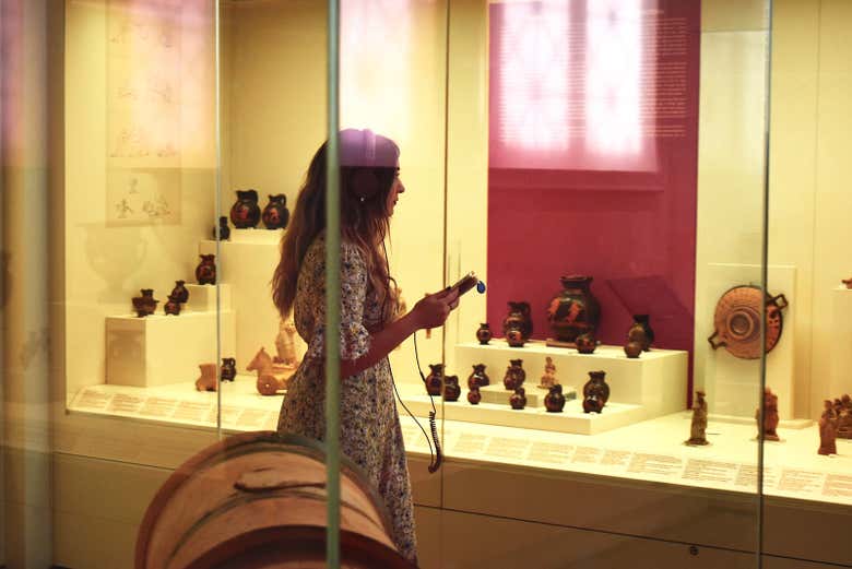 Una ragazza scolta l'audioguida del museo
