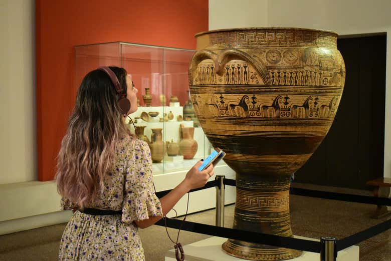 Una ragazza davanti a un'antica anfora del museo archeologico