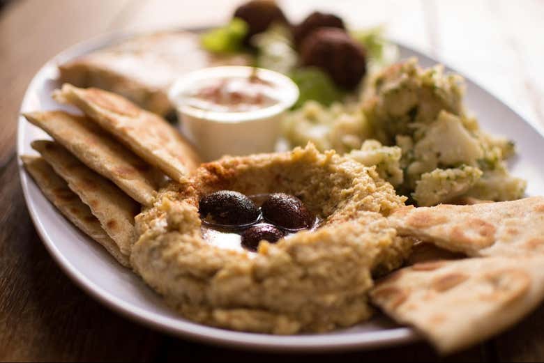 Plato de hummus acompañado de pan de pita