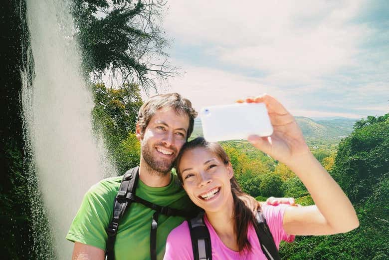 Um casal tirando uma selfie na cachoeira