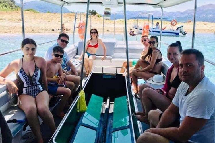 Um grupo de turistas no barco com fundo de vidro
