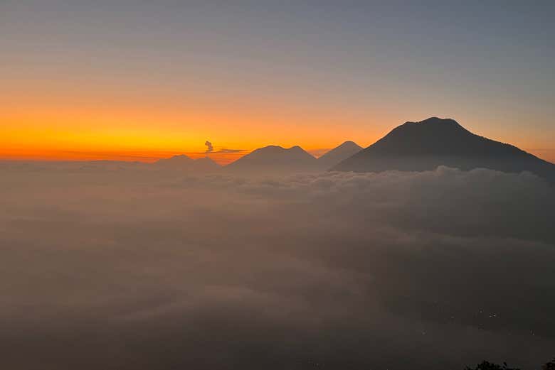 Un amanecer sobre las nubes y volcanes