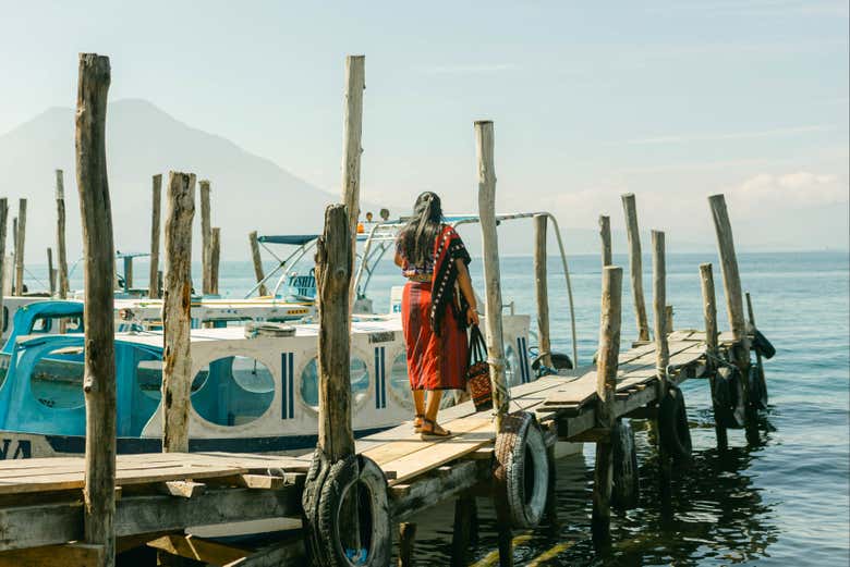 Un muelle y una mujer indígena en el lago Atitlán