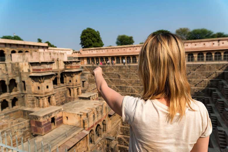 Uma turista contemplando o poço de Chand Baori
