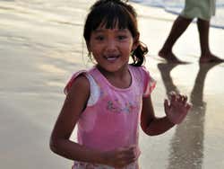 Niña en la playa de Jimbaran al atardecer