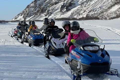Una fila de motos de nieve