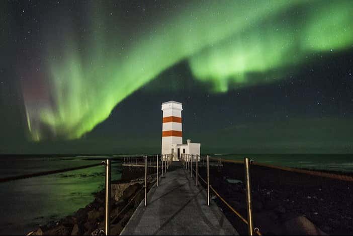 Luces del norte sobre un faro de Islandia