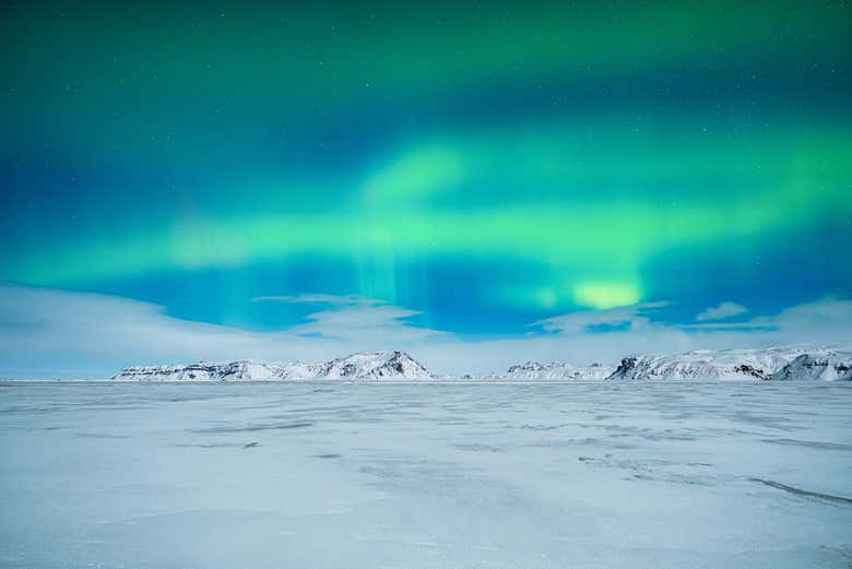 Aurore boréale sous un paysage enneigé