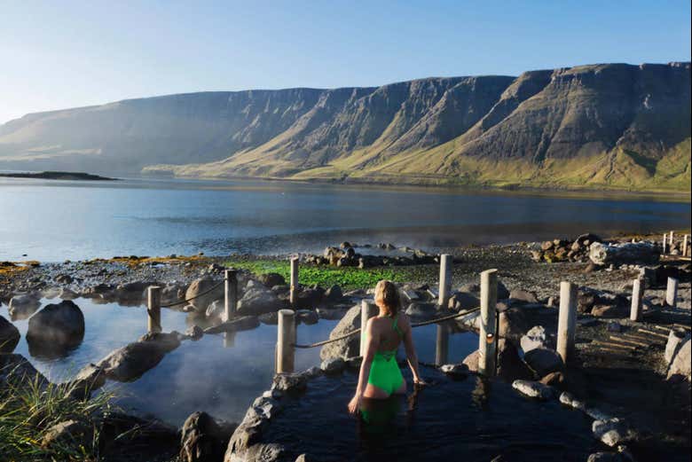 Uma mulher em uma das piscinas ao ar livre de Hvammsvík