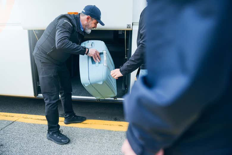 Driver placing luggage in storage area
