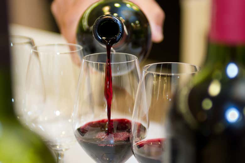 Sirviendo una copa de vino tinto