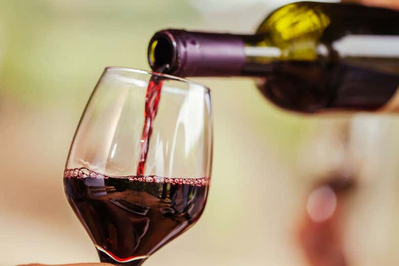 Sirviendo una copa de vino tinto