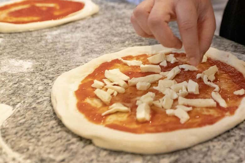 Aggiungendo ingredienti alla pizza