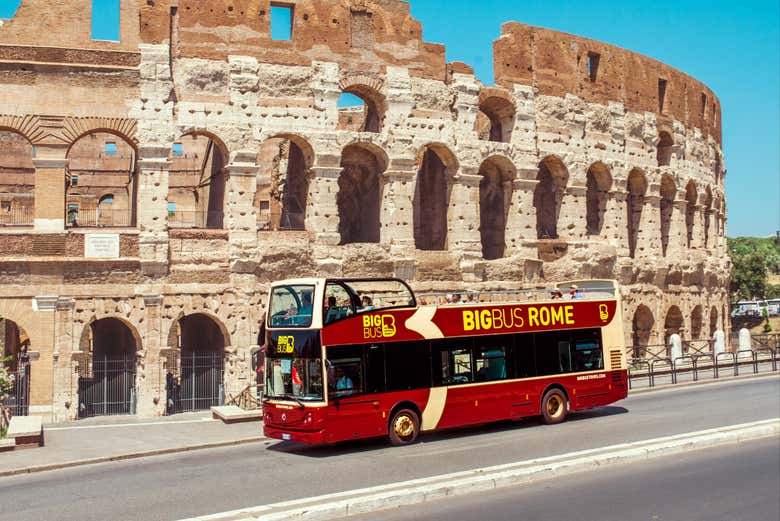 Autobús turístico de Roma pasando por el Coliseo