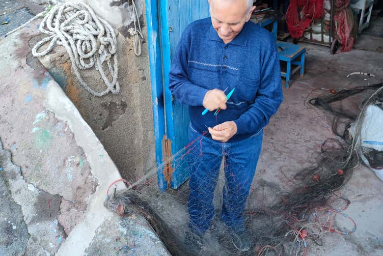 Un sognore che fabbrica reti da pesca