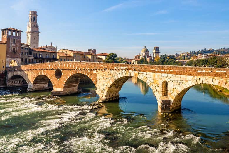 Cross the iconic Ponte di Pietra over the Adige